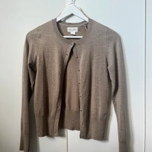 Kofta Lindex  - Jag säljer den här jättefina brun/beiga koftan från Lindex märke HOLLY&WHYTE. Säljer då den inte kommer till användning. Knappt användarhjälp nypris 349 kr. PRIS KAN DISKUTERAS🩷