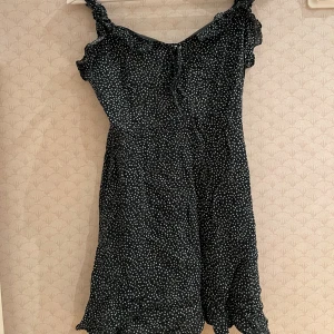 Grön miniklänning - Superfin mörkgrön miniklänning med små vita hjärtan och knytning. Knappt använd och i fint skick!