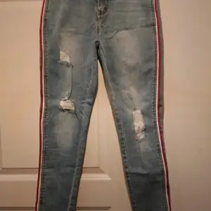 Helt nya jeans i ankle höjd. Fina slitningar och ett rött och vitt band längst sidan av benen. Kommer från ett djur och rökfritt hem 