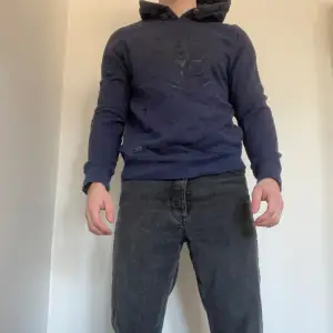En mörkblå hoodie med mörkt tryck! Jag är ca 180cm och väger 80kg