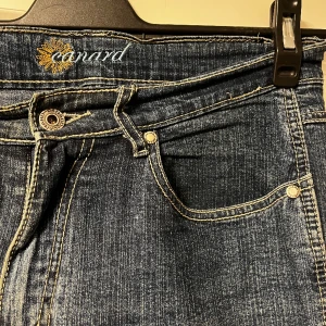Retro Jeans  - Sälj dom här super snygga byxorna som tyvärr inte kommer till andvänding längre. Jeansen passar dig som har 38/40 i storlek. Dom har en blomma på höger bakficka, vilket är en väldigt fin detalj. Jeansen är raka i bennen. 