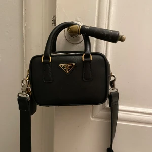 Prada väska  - Gott skick knappt använd  Liten Prada väska. Bandet har jag tappat bort så har ett annat temporärt. Detta kan följa med köpet om man så vill❤️☺️