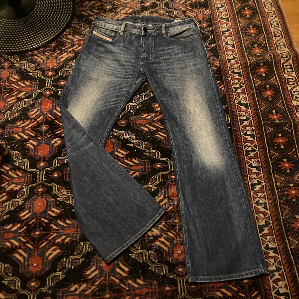 Snygga bootcut jeans från Diesel med modellen ”Zatiny - Regular Bootcut”. Vid benöppning som går snyggt över skorna. Skriv för mått mm. Jeans & Byxor.