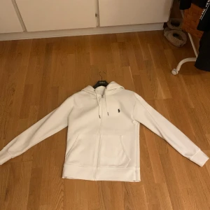 Polo Ralph lauren zip tröja vit Storlek S. - Säljer denna vita Polo Ralph Lauren tröja då den är förstor. Den är i storlek S men sitter mer som M. Den är använd i gott skick 9/10.