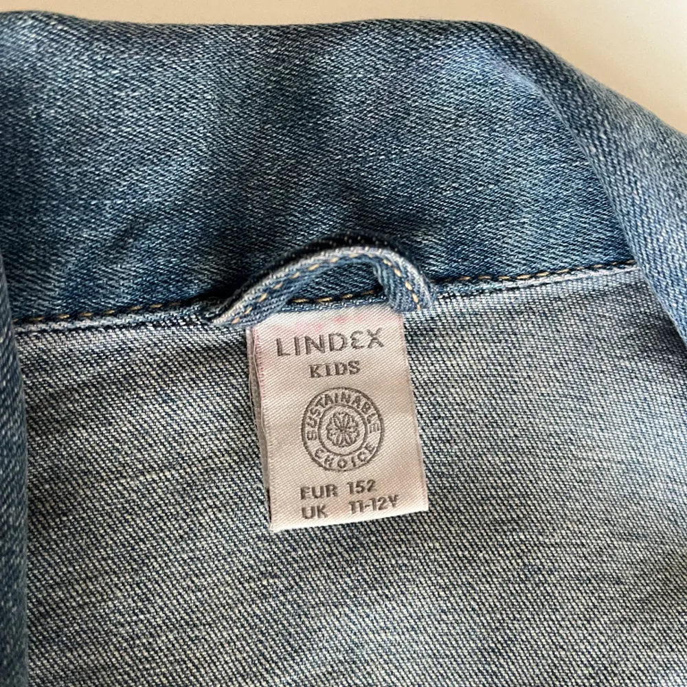 Fin jeansjacka ifrån Lindex. Pärlor i svart/grå och vit. Med lite detalj längst ner. Den är i storlek 152. Jag använder den inte längre för att jag har växt ur den💓. Jackor.