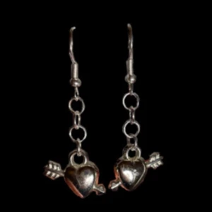 Nikki Earring - Säljs i par. Hjärtat (berlocken) är 1 cm bredd, och 1 cm hög. Pilen är 5 mm bredd och 1,8 cm lång (in räknat mått med hjärt - delen) Från högsta punkten på örhängeskroken till slutet av hjärtat (berlocken) är de 4,5 cm. 