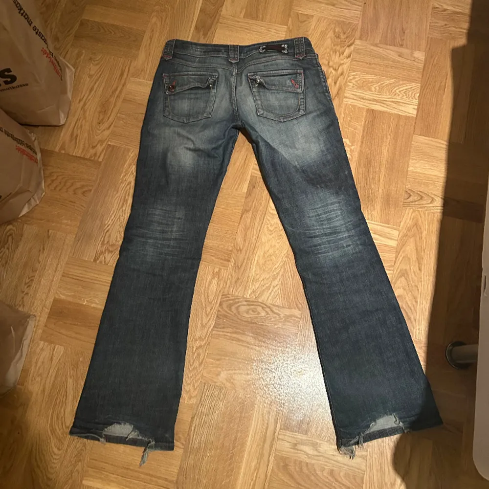 Skit snygga bootcut jeans med röda detaljer som jag säljer då de inte kommer till användning. Lite slitningar i hälen (skriv för blir bilder) Midjemått: 43cm, Innerbenslängd: 77cm!! Använd gärna köp nu 💝. Jeans & Byxor.