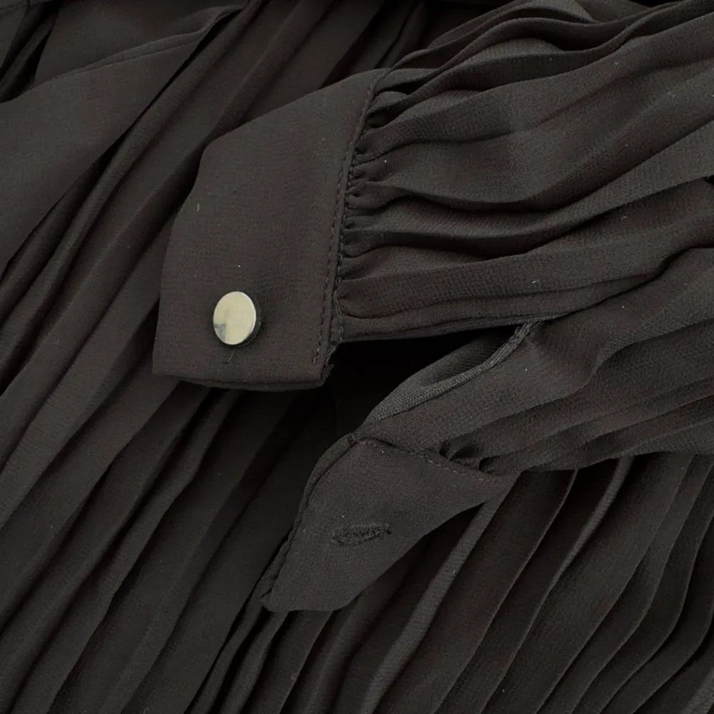 Oanvänd plisserad klänning i svart med eller utan knytskärp. Storlek s/m upplevs som onesize. Knappar vid handled och nacke.. Klänningar.