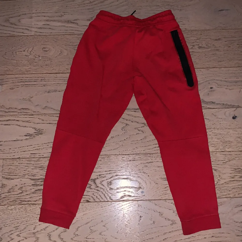 Nike tech fleece byxor röda, topp skick och knappt använda. Storlek Junior 147-158 cm. Jeans & Byxor.