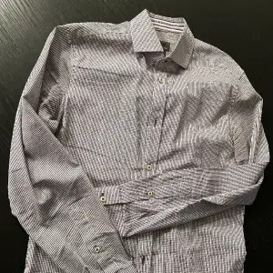 Stilren skjorta med lilla detaljer, köpt på HM, vuxit ur lch är i väldigt gott skick.
