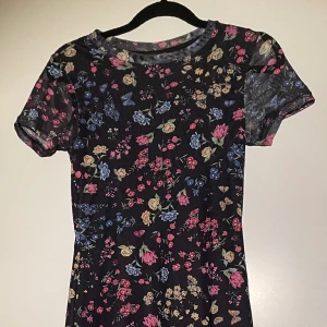 Blommig klänning  - Lite längre klänning går ca till knäna på mig (jag är 160cm) Det är en inner kjol/klänning sen ett tunnare/genomskinligt lager ovanpå. Sitter tajt upptill men ner mot benen blir den lite lösare som en kjol. Super skönt och luftigt material. 