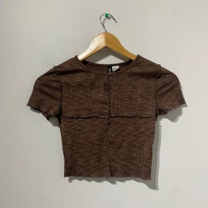 croppad topp - en brun topp som är croppad och sitter mot kroppen, materialet är ganska stretchigt så hade sagt att den kan passa som en S också. använd ganska mycket men bra skick.