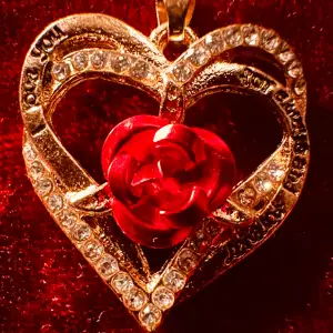 Så vackert och romantiskt halsband med ett hjärta av emalj innefattat av två andra hjärtan prydda med strass. Hjärtmedaljongen är 2,6 cm lång och 2,2 cm bred. Kedjan är maximalt 50 cm lång, kan justeras så den blir kortare. Ett riktigt kärleksbevis!