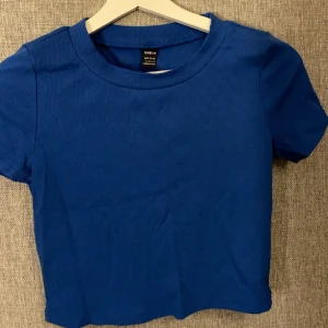 Blå t-shirt  - Varan är i nyskick inte använt den något då den är ganska kort på mig och gillar inte det.