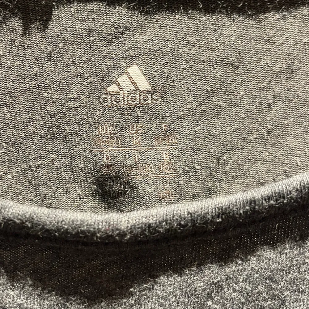 Träningströja från Adidas med text på baksidan. Hoodies.