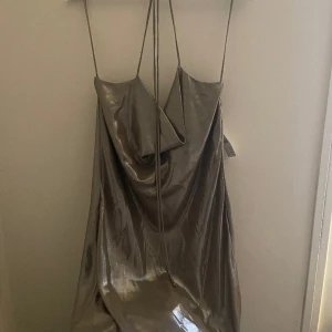 Miniklänning i silkes - Miniklänning i silkes med ett litet djup i ryggen. Halterneck knytning. Inte använd, prislappen är kvar.