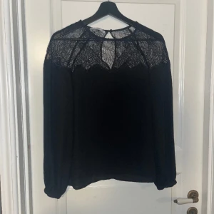 Blus - En svart blus med spets upptill. Från mango suit i storlek S.