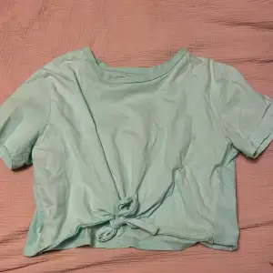 En croppad T-shirt med en knut längst fram. Inga fläckar eller liknande.