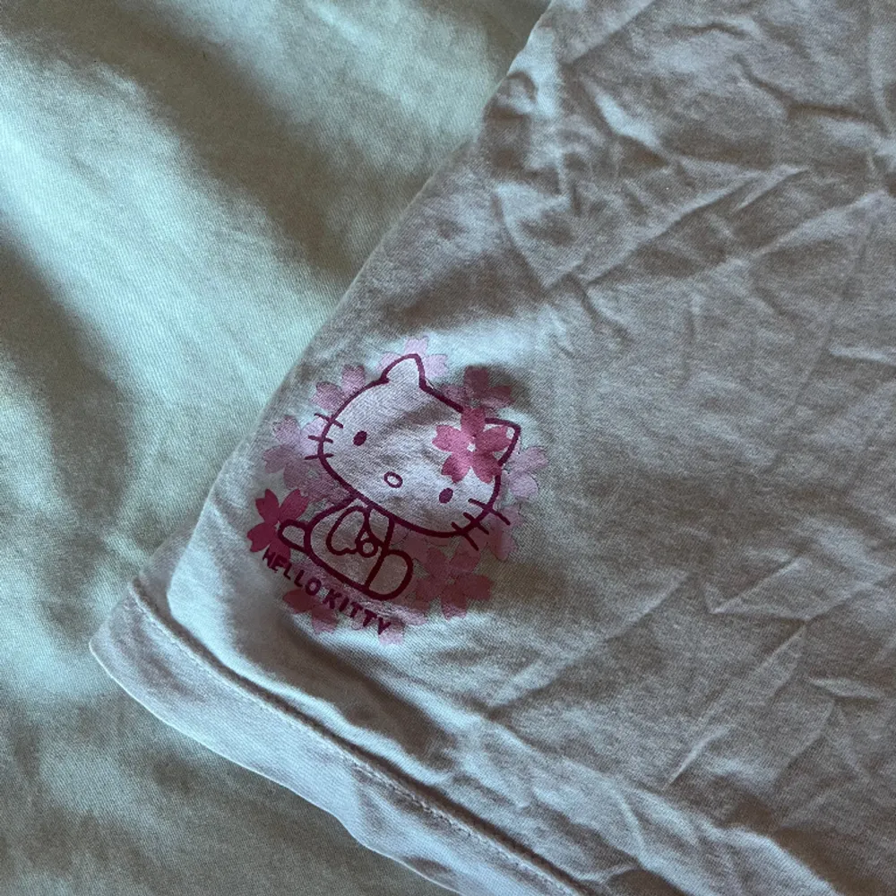 En baby topp i ljusrosa med Hello Kitty tryck. Passar XS.   Köparen står för frakt. . Toppar.