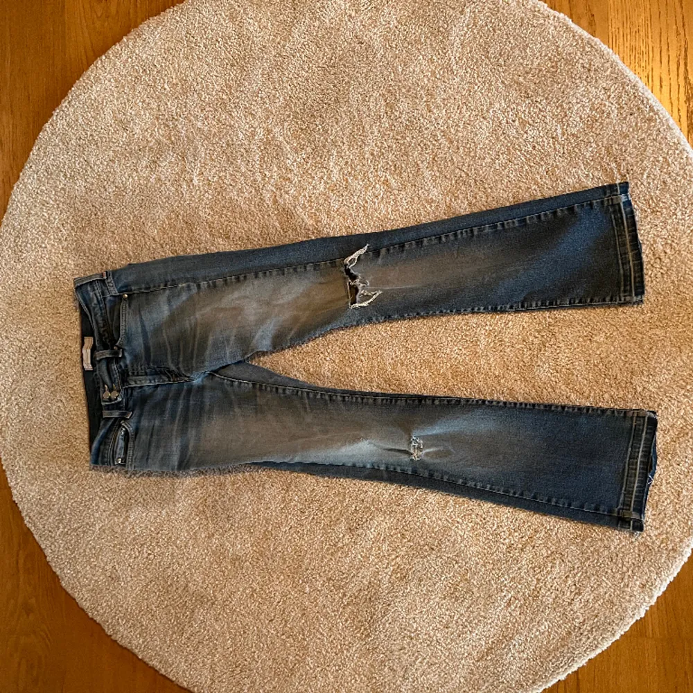 Super snygga bootcut jeans! Uppklippta då dom va för kort, har hål vid benen (kolla bild)! Midja: 70cm, inneben: 73cm, ytterben: 94cm. Jeans & Byxor.