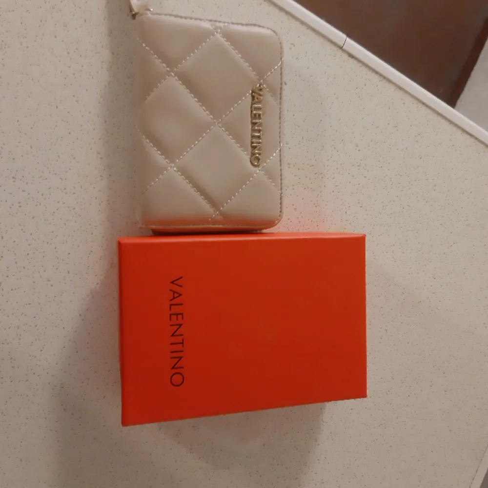 Valentino ocarina plånbok färg ecru inköpt på zalando använd 4 ggr mycket bra skick . Väskor.