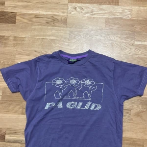 Rhinestone T-shirt - Fin lila rhinestone T-shirt där det står ”på glida på! En rhinestone som lossnat men syns knappt