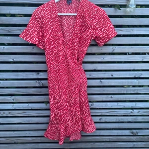 Röd VeroModa klänning - Säljer denna röda veromodaklänningen då den inte används❤️! Den har inga defekter. Det finns ett knytband som man kan knyta hur hårt man vill att den ska sitta🤍.