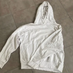 Vit hoodie - En vit hoodie med långa ärmar och en huva. 