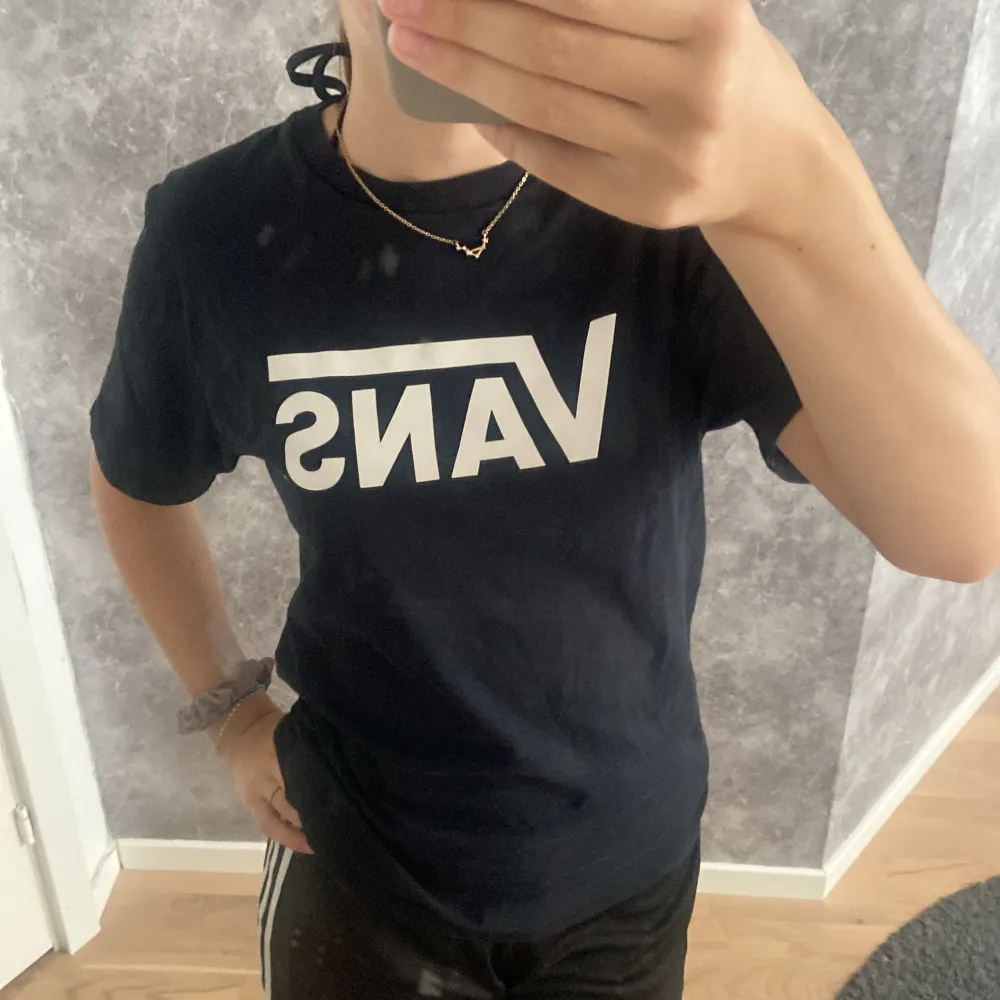 En skön och svart t-shirt från Vans med vit Vans logga på framsidan. T-shirten är tillverkad av 100% bomull och har en normal passform.. T-shirts.