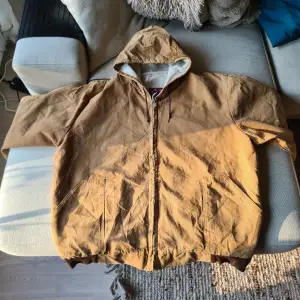 XL, 1990-2000s arbetsjacka, carhartt liknande, made in USA.  Superfrän vintage arbetsjacka för dig som vill ha komforten av en carhartt för 1/4 av priset. Sitter stort och har en liten slitning på axeln. Passar perfekt för dig som söker retro looken!