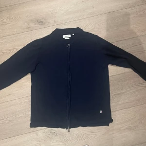 Marinblå Helzip - Strömberg Colletion - Säljer denna marinblåa tröja ifrån Ströberg Collection, i väldigt bra skick, eftersom den inte passade som förväntat. Storleken är L.