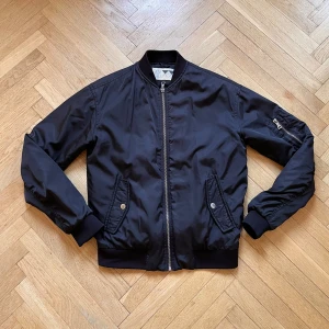 Svart bomberjacka från Junkyard - Välanvänd jacka men i fint skick. Passar bra till sommarkvällen eller till våren.