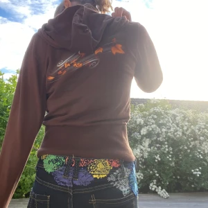 Zip up Y2K tryck trendig - 2000 tals liten brun tröja med luva och tryck på båda sidorna. Tyget är jättemjuk och lite tunt som är behagligt i lite varmare och svalare väder. Själva tröjan är i väldigt bra skick. Kontakta gärna vid frågor eller diskutera pris❤️