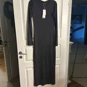 En lång grå klänning från Ginatricot som aldrig är använd, prislappen sitter kvar🩷 Köpare står för frakt
