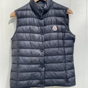 Moncler Liane Gilet - Väst från Moncler, modell Liane Gilet. Köpt på Moncler i Stockholm. Kvitto saknas men den är registrerad på Monclers hemsida för att intyga äkthet! Använd sparsamt, lite smutsig men som ny. Storlek 3, motsvarande S. Hör av dig för mer bilder!
