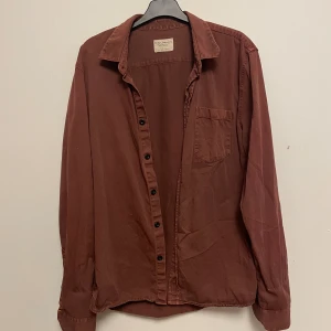 Vinröd jeansskjorta  - Jeansskjorta från Nudie Jeans, sliten stil men sparsamt använd! 