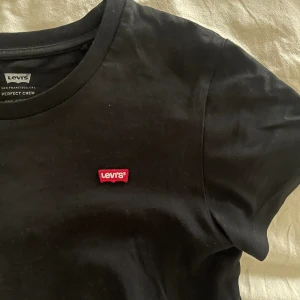 Tshirt - Svart T-shirt från Levi’s som knappt är använd. Den är i strl XXS men jag upplever den som större🖤