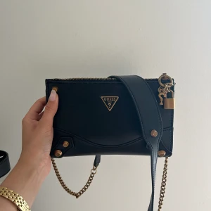Väska - Skitsnygg väska från guess. Köpt för 1300kr från Zalando. Svart med guld detaljer👊🏼pris kan diskuteras 