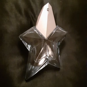 Mugler Angel flaska - OBS detta är bara flaskan, den innehåller INTE parfym! Det går att köpa refills av parfymen och fylla på! Några repor på metallen men annars i fint skick, jag skickar gärna fler bilder vid intresse!