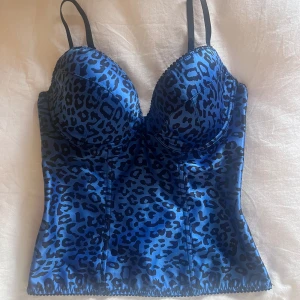 Korsettopp  - Cool leopardmönstrad blå korsettopp, skulle säga att storleken är ungefär en M men en C/D kupa, justerbar knäppning i ryggen med krokar! Bilderna i annonsen är de som finns