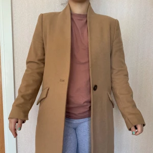 100% Ullkappa MNG | Mango | Ytterplagg Dam Jacka TjejKläder - 100% Italiensk Ull certifierad av Picchi.  MNG/Mango kappan är i mycket bra skick. Storlek: Small Längd: 94cm  Axelbredd: 42 cm Nypris: 1399 kr Mitt pris: 349 kr  Kan skickas med spårbar post eller hämtas i Bromma. Kan även samskickas med mina andra 