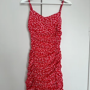 Klänning från Nelly (Parisian)  - Kort blommig klänning från Nelly (Parisian). Jättefint skick och endast använd 1 gång. Dragkedja i bak. Strl. 34. 