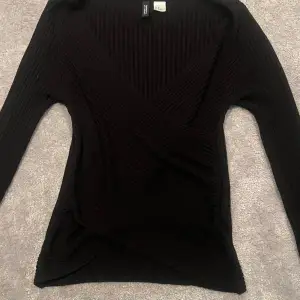 En svart tröja från divided h&m, ribbad och perfekt till sommaren men även vintern, skönt material och aldrig använd, strl S men funkar även till Xs, og pris 129kr🤩
