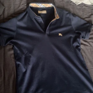 Burberry Piké Navy blå  - Tjena , säljer en Navy blå burberry Piké som jag använt endast 2 gånger. Har en lika Dan fast i vit färg så därför säljer jag den.   Inga defekter / lappen finns kvar bara att jag tog bort den från tröjan. Om snabb och smidig affär, kan jag gå ner