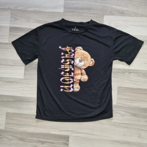 T-shirt  - Svart T-shirt med tryck av en nalle och text från shein,  knappt använd och är som ny.    