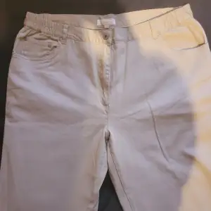 Beiga jeans i mjukt material  Ankellånga  Broderie på bakfickorna Riktiga/djupa fickor bak och fram