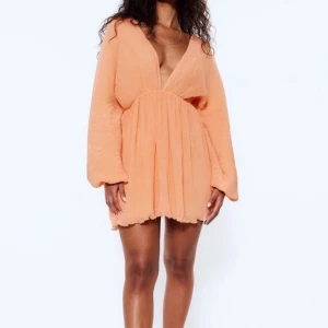 Sommarklänning  - Super fin orange sommarklänning från Lojsans kollektion med Nakd som inte säljs längre! Den har en ritat fläck på sig på baksidan (skriv för bild) som förmodligen går bort i tvätten! Storlek 34💕