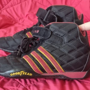 Adidas Goodyear  - Sneakers från 2004, Racer från Adidas i samarbete med Goodyear. Tyg och mocka. Svarta, röda och gula. Liten i storlek mer som en bred 39:a.