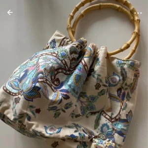 Sommarväska  - Fint skick  Sommarväska med vitt bottenfärg brun / blåa mönster Bambu handtag  