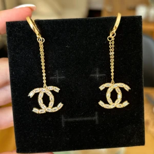 Hängande chanel örhängen - Chanel inspirerade örhängen (ej äkta). Endast använda en gång! Guld och ”loggan” har stenar. 